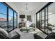 Cozy living room featuring large windows, stylish furniture, and modern chandelier at 4214 E 8Th Pl, Denver, CO 80220