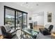 Bright living room with large windows, modern chandelier, stylish furniture, and outdoor living space at 4214 E 8Th Pl, Denver, CO 80220