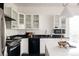 Modern kitchen features stainless steel appliances, black countertops, white cabinets, and a central island at 1438 Little Raven St # 104, Denver, CO 80202