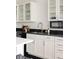 Well-lit kitchen showcasing white cabinets, black countertops, stainless steel sink, and sleek fixtures at 1438 Little Raven St # 104, Denver, CO 80202