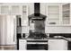 Modern kitchen with stainless steel appliances, white cabinets, and a sleek black range hood at 1438 Little Raven St # 104, Denver, CO 80202