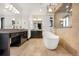 Luxurious bathroom with dual vanities, a freestanding tub, and elegant lighting at 8680 Summerlin Pl, Longmont, CO 80503