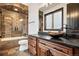 Luxury bathroom features stone tile surround, bathtub, and granite countertop vanity with sink at 8680 Summerlin Pl, Longmont, CO 80503