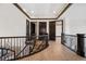 Spacious hallway boasts hardwood floors, dark trim and doors, and decorative iron railing staircase at 8680 Summerlin Pl, Longmont, CO 80503