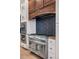 Close up of a stainless steel stove with custom range hood and backsplash in the kitchen at 8680 Summerlin Pl, Longmont, CO 80503