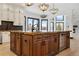 Custom kitchen with large center island with granite countertops and stainless steel beverage cooler at 8680 Summerlin Pl, Longmont, CO 80503