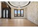 Elegant living room with stone accent wall, designer lighting, and large windows at 8680 Summerlin Pl, Longmont, CO 80503