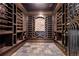 Rustic wine cellar features custom wood racking, stone accents, and slate flooring for storing collections at 8680 Summerlin Pl, Longmont, CO 80503