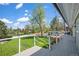 Scenic backyard featuring lush green lawn, trees, and a large deck with white railing and stairs at 6150 S Southwood Dr, Centennial, CO 80121