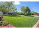 Expansive backyard with lush green lawn, mature trees, landscaping and terraced retaining wall at 6150 S Southwood Dr, Centennial, CO 80121