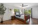 Comfortable bedroom with wood accents, a ceiling fan, bedside tables, lamps, and a window view at 6150 S Southwood Dr, Centennial, CO 80121
