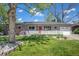 Charming ranch-style home with lush front lawn, red door, and inviting porch at 6150 S Southwood Dr, Centennial, CO 80121