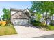 Charming two-story home featuring a stone facade, lush lawn, and an attached two-car garage at 19817 E Prentice Ave, Centennial, CO 80015