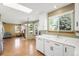 Bright kitchen featuring white cabinets, modern appliances, wood floors, and a view to the living area at 19817 E Prentice Ave, Centennial, CO 80015