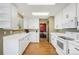 Well-lit kitchen featuring white cabinets, stainless steel appliances, and open access to the dining room at 19817 E Prentice Ave, Centennial, CO 80015