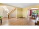 Open living room featuring hardwood floors, staircase, and an arched entryway to the dining area at 19817 E Prentice Ave, Centennial, CO 80015