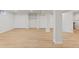 Open basement with wood floors, columns, several doors, shelving, and closet space at 41 Eagle Dr, Littleton, CO 80123