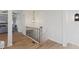 Bright hallway with hardwood floors and elegant lighting fixture with modern handrail and stairs at 41 Eagle Dr, Littleton, CO 80123