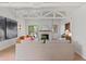 Open living room with vaulted ceilings, white beams, brick fireplace and access to outdoor deck at 41 Eagle Dr, Littleton, CO 80123