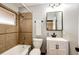 Updated bathroom featuring a shower-over-tub, tile surround, new vanity, and modern fixtures at 1945 Yosemite St, Denver, CO 80220