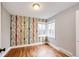 Cozy bedroom with colorful tree-patterned wallpaper, hardwood floors, and a bright corner window at 1945 Yosemite St, Denver, CO 80220