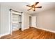 Bedroom with hardwood floors, ceiling fan, and a closet with sliding doors for optimal storage at 1945 Yosemite St, Denver, CO 80220