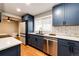 Well-lit kitchen featuring stainless steel appliances, dark blue cabinets, and quartz countertops at 1945 Yosemite St, Denver, CO 80220