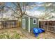 Exterior shot of a shed, adjacent to a wooden fence and pile of wood, providing practical outdoor storage at 1945 Yosemite St, Denver, CO 80220