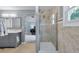Light-filled bathroom featuring a walk-in shower and a gray vanity with double sinks at 7900 E Iowa Ave, Denver, CO 80231
