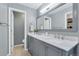 Gray bathroom featuring dual sinks, granite countertops, and modern fixtures at 7900 E Iowa Ave, Denver, CO 80231
