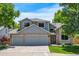 Charming two-story home boasts a three-car garage, well-manicured lawn, and mature trees at 7900 E Iowa Ave, Denver, CO 80231