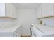 Clean laundry room with white cabinetry, sleek countertops, and modern appliances for efficient laundry tasks at 7900 E Iowa Ave, Denver, CO 80231