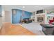 Comfortable living room featuring a brick fireplace, built-in shelving, and a mix of carpet and hardwood flooring at 7900 E Iowa Ave, Denver, CO 80231