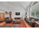 Open-concept living room with hardwood floors, vaulted ceilings, and large windows at 7900 E Iowa Ave, Denver, CO 80231