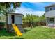 Backyard playhouse with slide and swing set, surrounded by lush greenery on a sunny day at 7900 E Iowa Ave, Denver, CO 80231