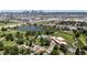 Aerial view of a city park with a pond, playground, sports fields, and a skyline in the distance at 46 S Perry St, Denver, CO 80219
