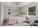 Cozy bedroom with a large window, floral artwork, wood floors, and neutral decor at 46 S Perry St, Denver, CO 80219