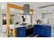 Bright kitchen with blue lower cabinets, white uppers, stainless appliances, and stylish vent hood at 46 S Perry St, Denver, CO 80219