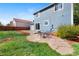 Spacious backyard featuring a stone patio, lush green lawn, and privacy fence at 1444 S Richfield Way, Aurora, CO 80017