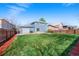 Overview of the fenced backyard featuring a detached garage, mature trees, and a patio at 1444 S Richfield Way, Aurora, CO 80017