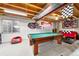 Finished basement featuring a pool table, exposed wood ceiling, and casual seating area at 1444 S Richfield Way, Aurora, CO 80017