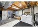 Functional basement laundry area with washer, dryer, and a cozy seating space at 1444 S Richfield Way, Aurora, CO 80017