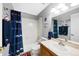 Bathroom featuring a shower and tub combination with Broncos-themed decor and white tiled walls at 1444 S Richfield Way, Aurora, CO 80017