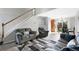 Open-concept living room with stairway and neutral color palette, flowing into the dining area and kitchen at 1444 S Richfield Way, Aurora, CO 80017