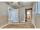 Bedroom with carpet, a window, and an open doorway leading to an ensuite bathroom at 6660 Locust St, Commerce City, CO 80022