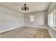 Neutral-toned bedroom featuring a modern light fixture and natural light from two windows at 6660 Locust St, Commerce City, CO 80022