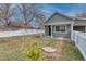 Front exterior view of a cozy one-story house with a well-maintained lawn, white fence, and a welcoming front entrance at 6660 Locust St, Commerce City, CO 80022