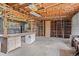 Unfinished basement featuring exposed beams, concrete floors, a workbench, and built in shelving at 7350 Field St, Arvada, CO 80005