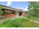 Classic single-story home featuring a brick facade, a covered porch, and mature landscaping at 7350 Field St, Arvada, CO 80005