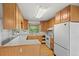 Bright kitchen features wood cabinets and a white refrigerator at 7350 Field St, Arvada, CO 80005